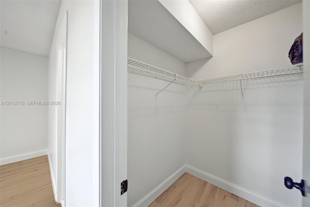 Walk-in closet featuring wood-finish flooring and white wire shelving