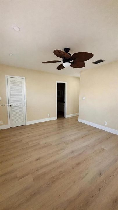 Room featuring wood-finish flooring, recessed lighting, and a multi-blade ceiling fan with an integrated light fixture