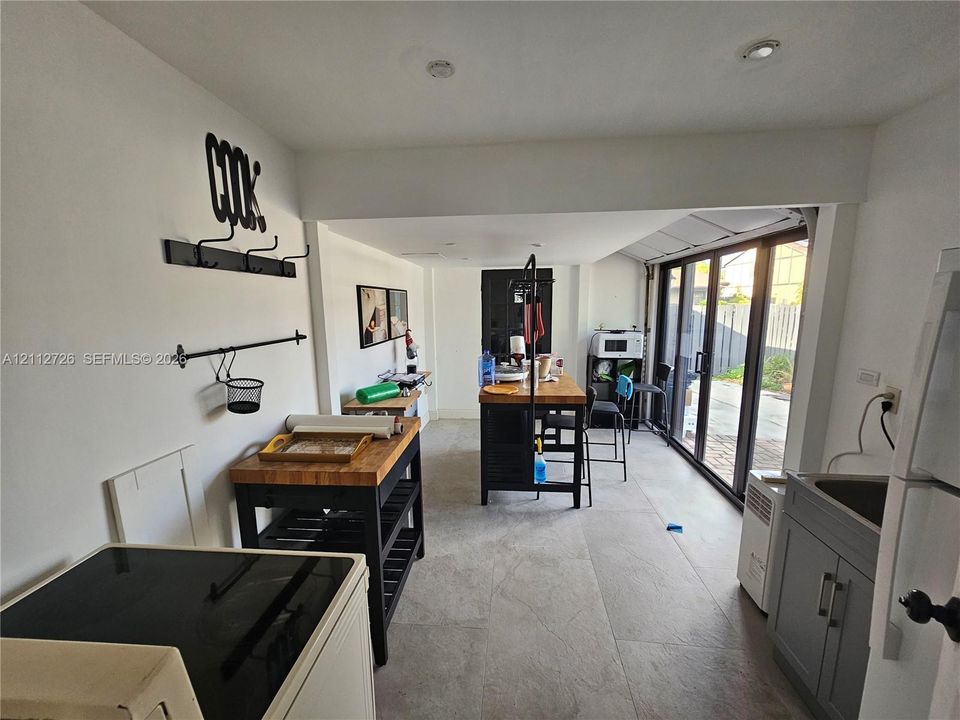 Large-format tile flooring, recessed ceiling lighting, and a multi-panel glass door system leading to the exterior