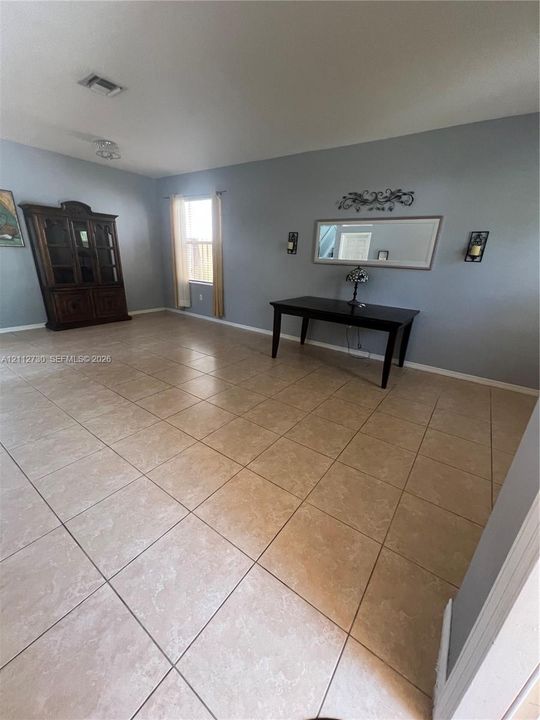 Neutral-toned ceramic tile flooring, soft grey wall color, and recessed ceiling lighting
