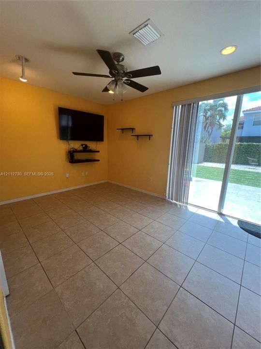 Ceramic tile flooring, ceiling fan with integrated lighting, recessed lighting, wall-mounted shelving, and sliding glass doors