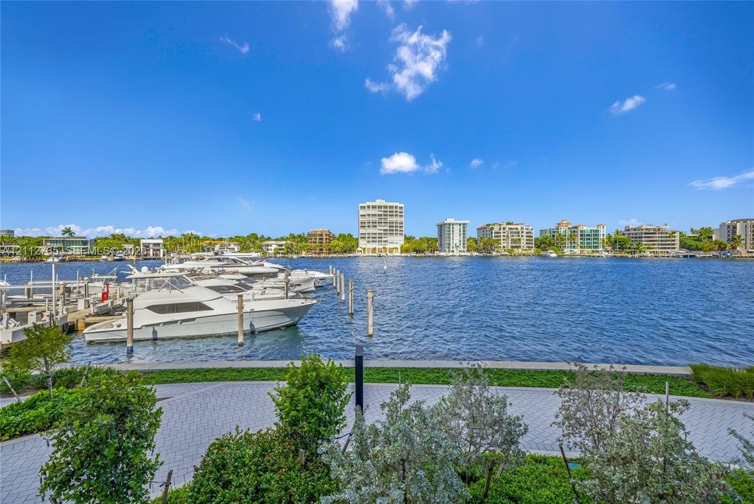 Waterfront property featuring a concrete seawall, paver-stone walking path, integrated landscaping, and direct deep-water frontage