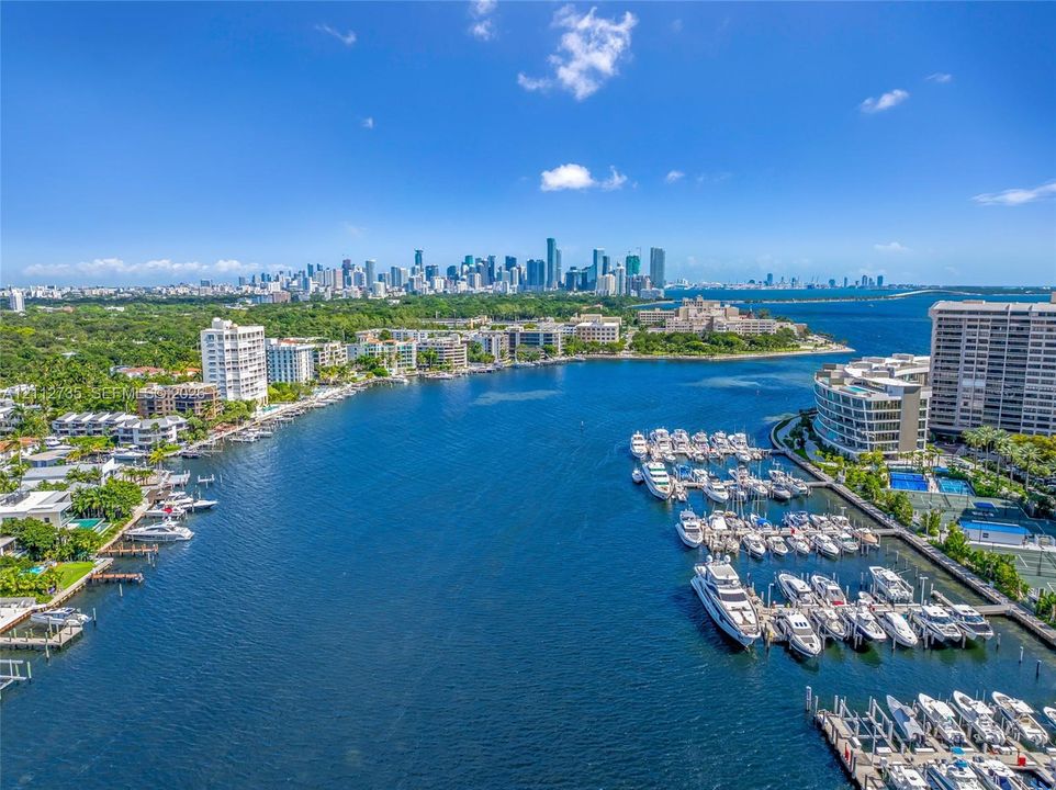 Aerial perspective of deep-water frontage featuring a multi-slip private marina, boat docking infrastructure, and direct water access