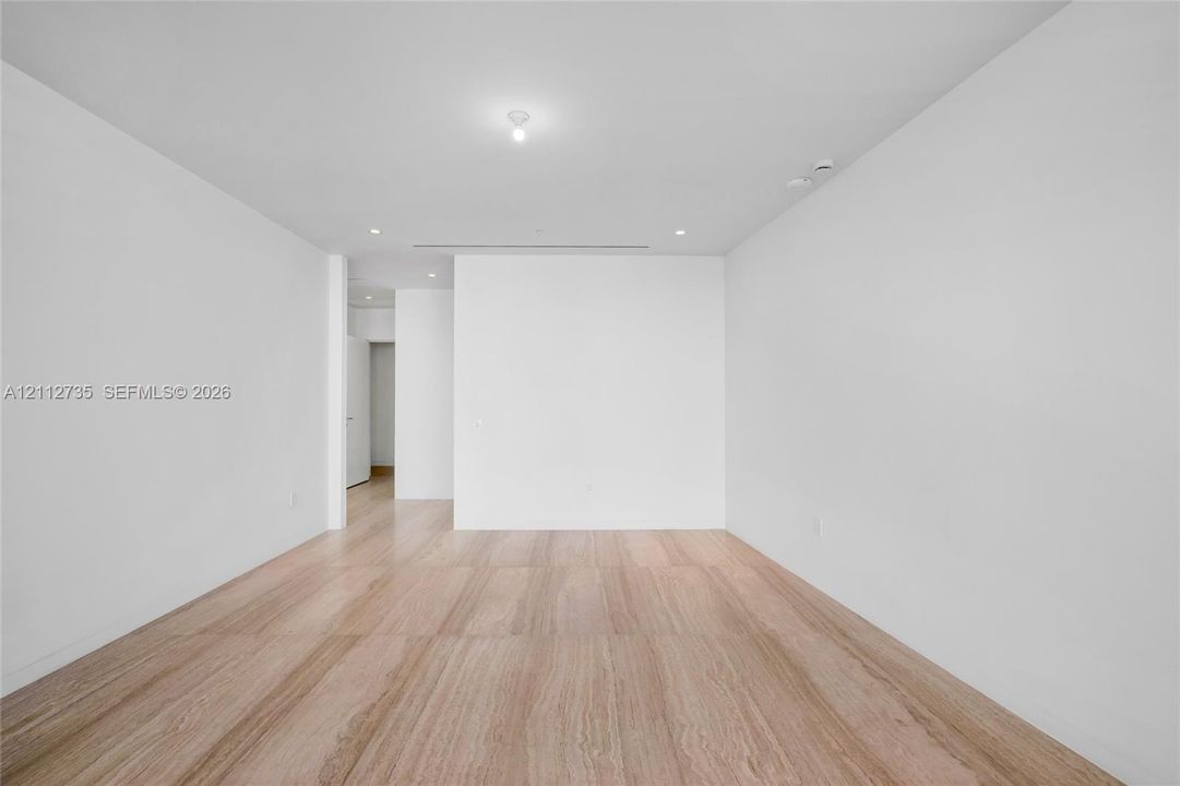 Interior space featuring light wood-finish flooring, smooth white walls, recessed ceiling lighting, and a linear slot ceiling diffuser