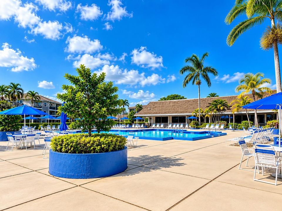 Community swimming pool featuring a concrete deck, perimeter palm trees, and structural planters