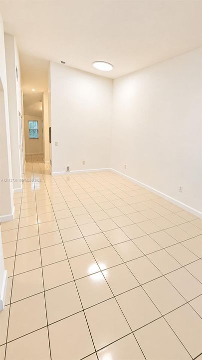 Interior space featuring high vaulted ceilings, neutral wall finishes, and light-toned ceramic tile flooring