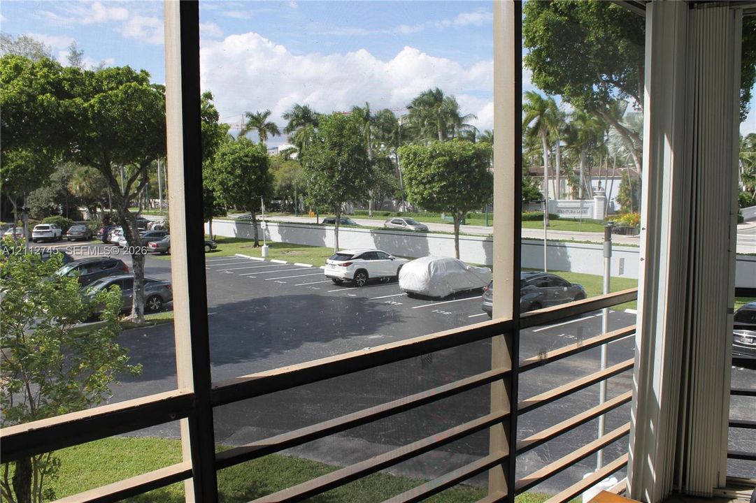 Screened-in enclosure featuring horizontal metal railings and vertical framing