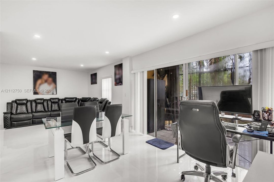 Spacious interior featuring large-format tile flooring, recessed lighting, and expansive sliding glass doors