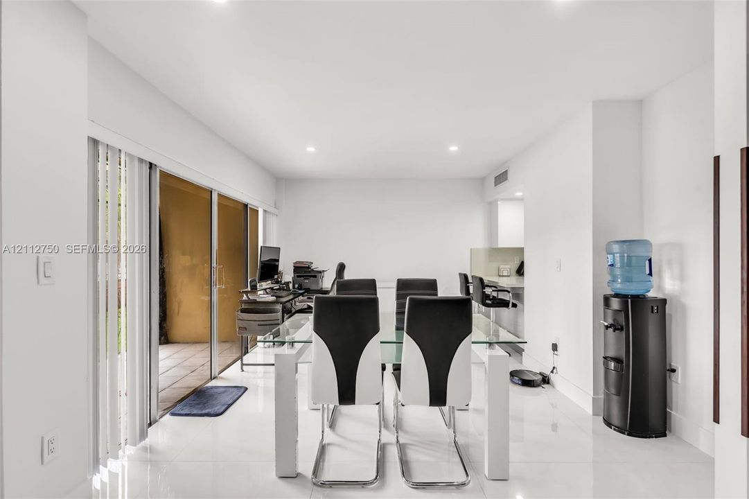 Open-concept interior space featuring polished tile flooring, recessed lighting, and expansive floor-to-ceiling glass sliding doors