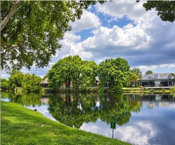 Waterfront property featuring a manicured lawn, mature trees, and natural landscaping