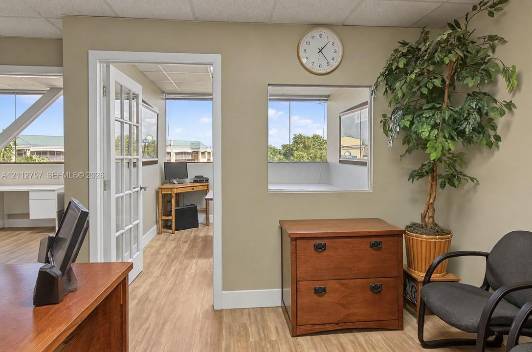 Wood-finish flooring, interior glass-paneled door, and recessed windows featuring exterior scenery