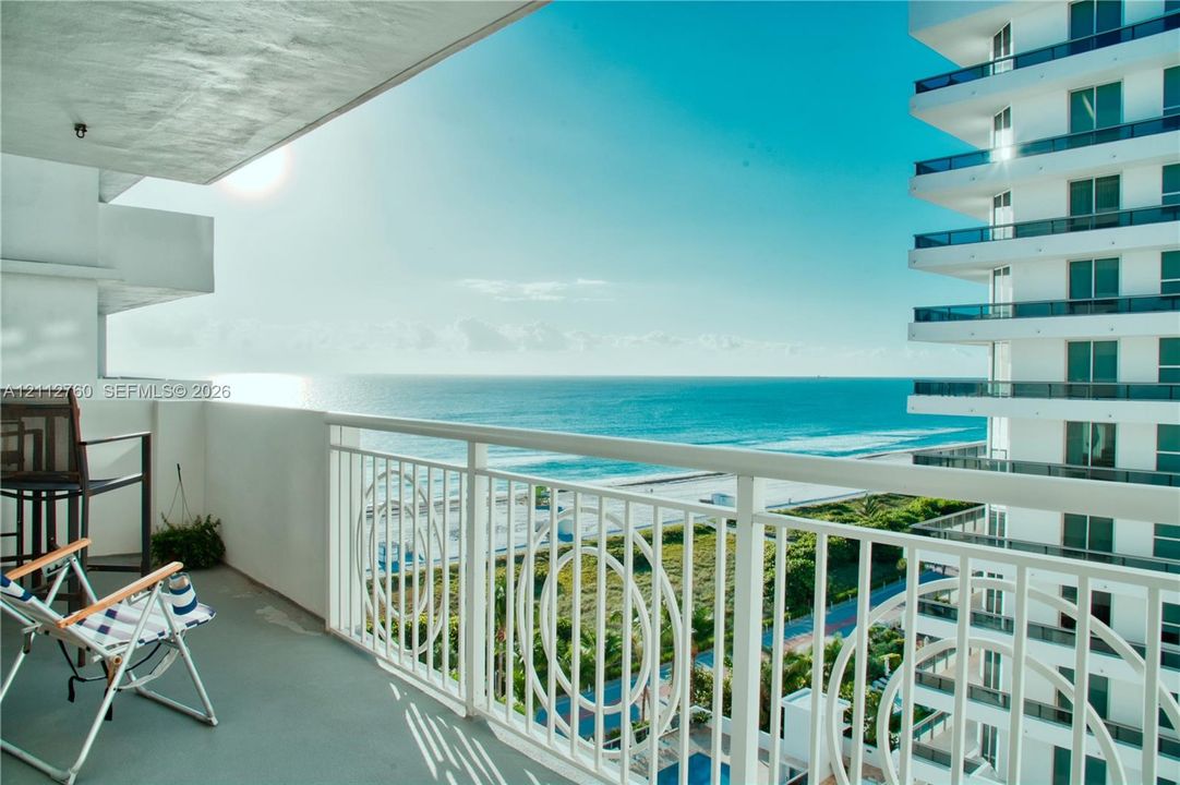 Private balcony featuring white metal railings with decorative circular detailing and oceanfront exposure