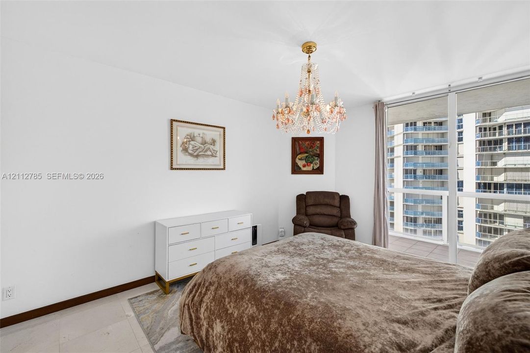 Floor-to-ceiling windows, crystal chandelier, and light-toned tile flooring