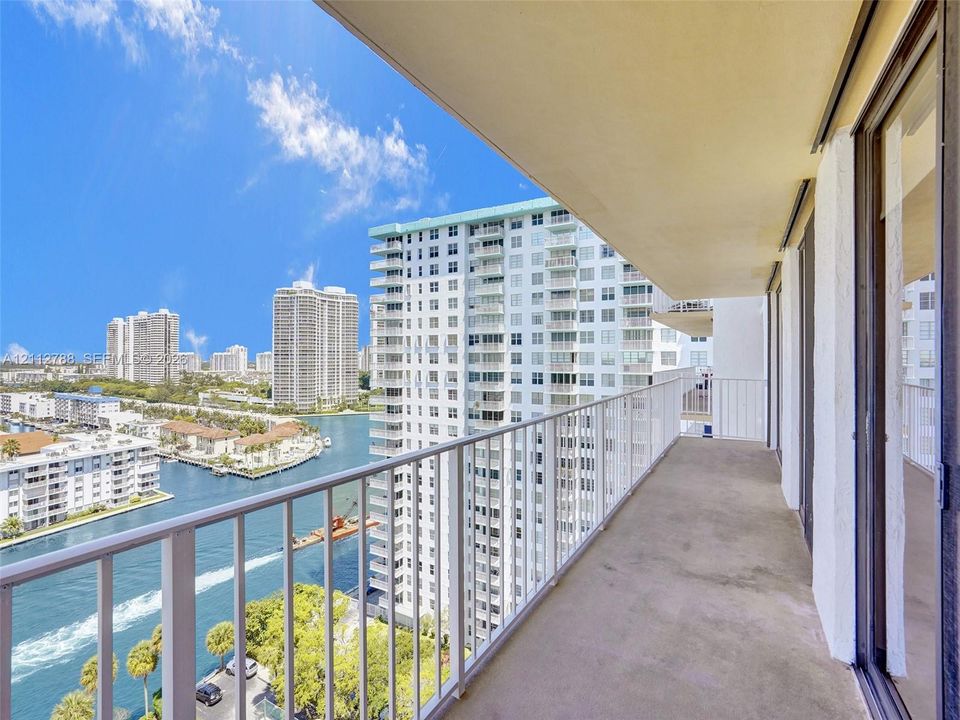 Covered balcony featuring concrete flooring and a full-height white metal railing