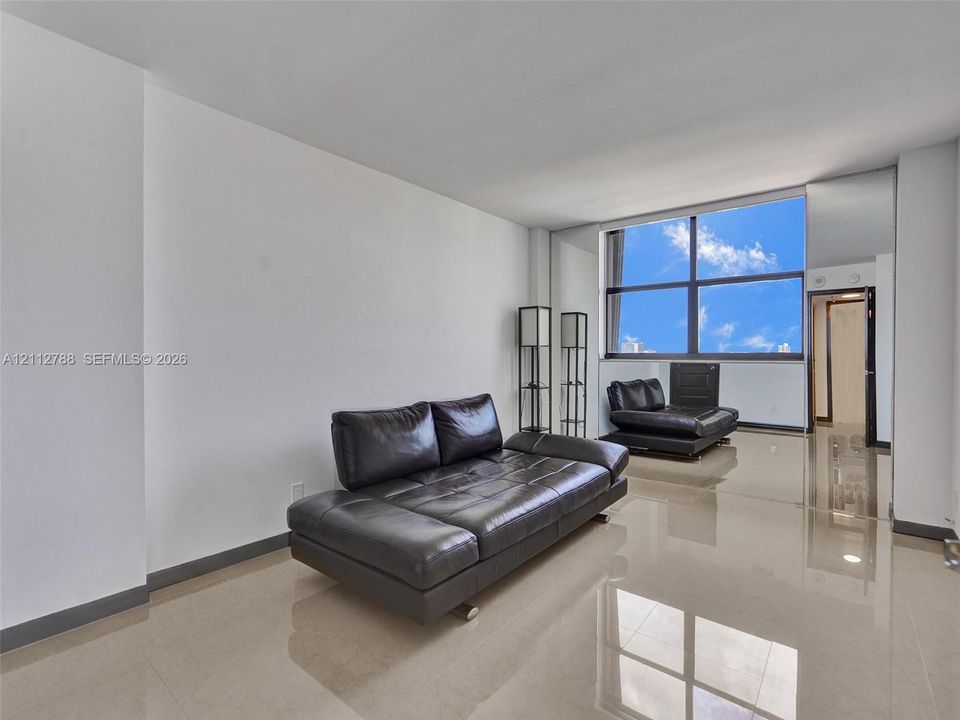 Large-format tile flooring, expansive floor-to-ceiling windows, and mirrored wall accents