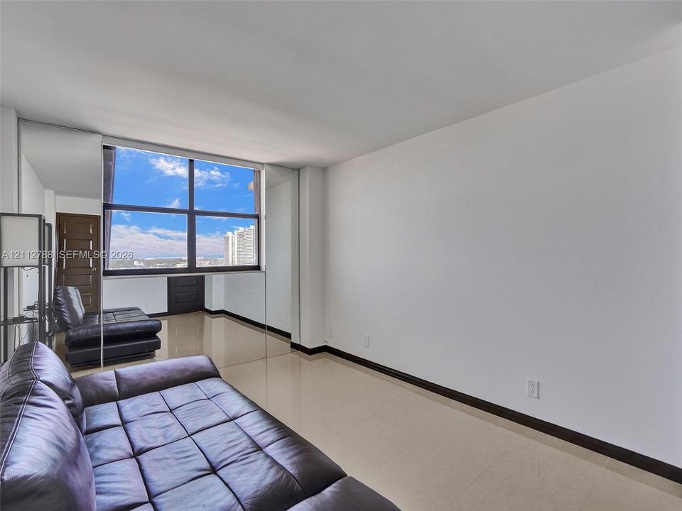 Expansive, multi-pane window with exterior scenery, polished tile flooring, and mirrored wall panels