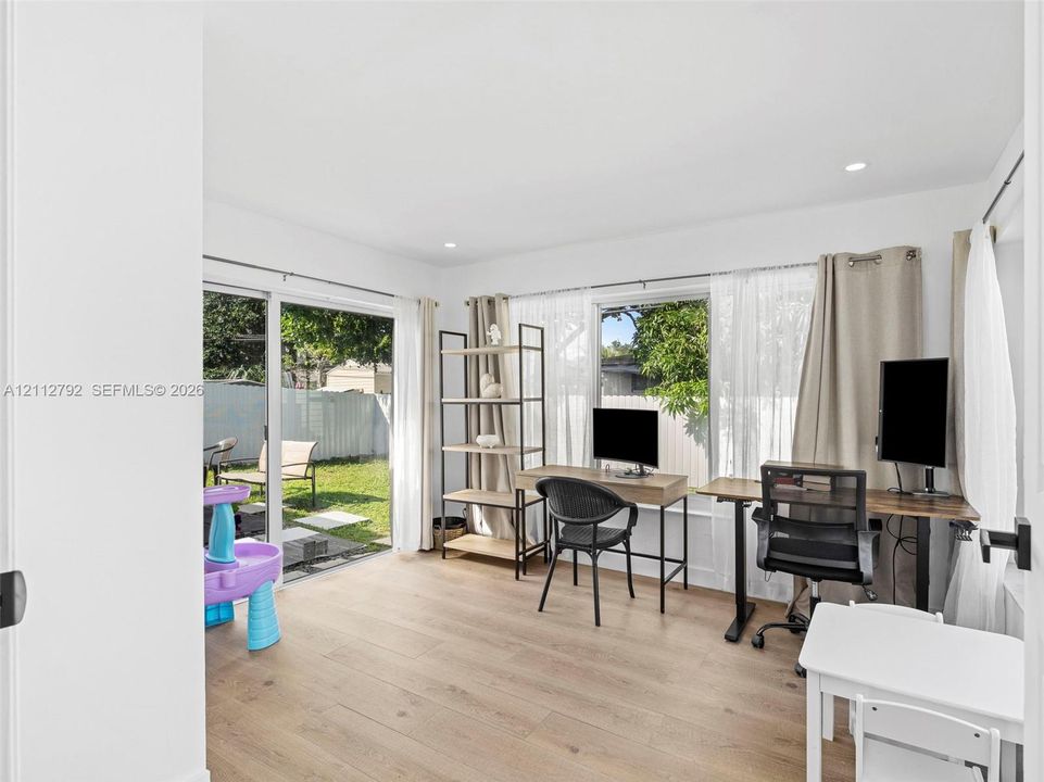 Interior space featuring wood-finish flooring, sliding glass door, and large window expanse with recessed lighting