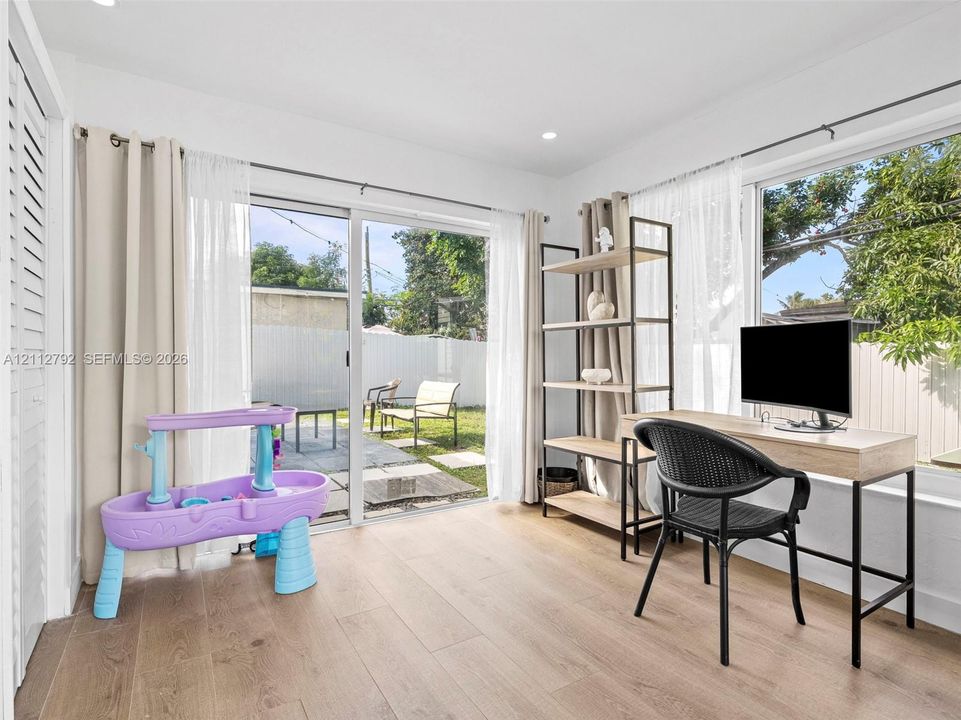 Wood-finish flooring, recessed lighting, and large sliding glass doors providing external access