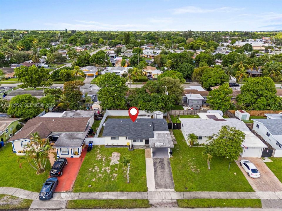 Single-story residence featuring a shingle roof, attached carport, concrete driveway, and a white privacy fence