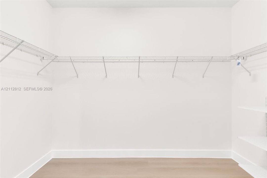 Walk-in closet featuring wood-finish flooring and white wire shelving