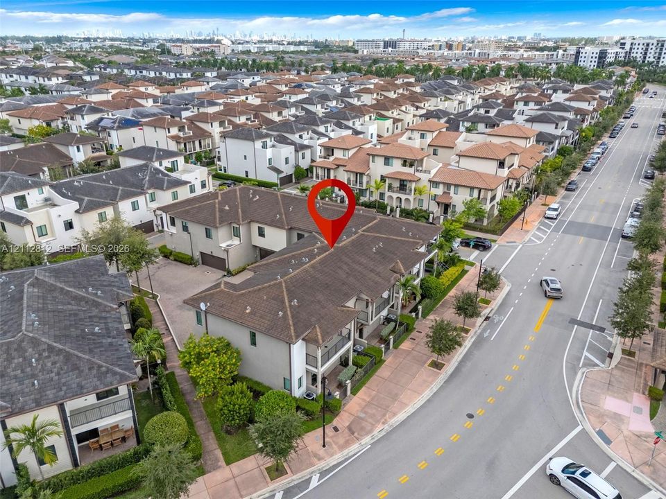 Aerial perspective of multi-level residential structures featuring hip-style rooflines, stucco exteriors, covered balconies, and paved driveways