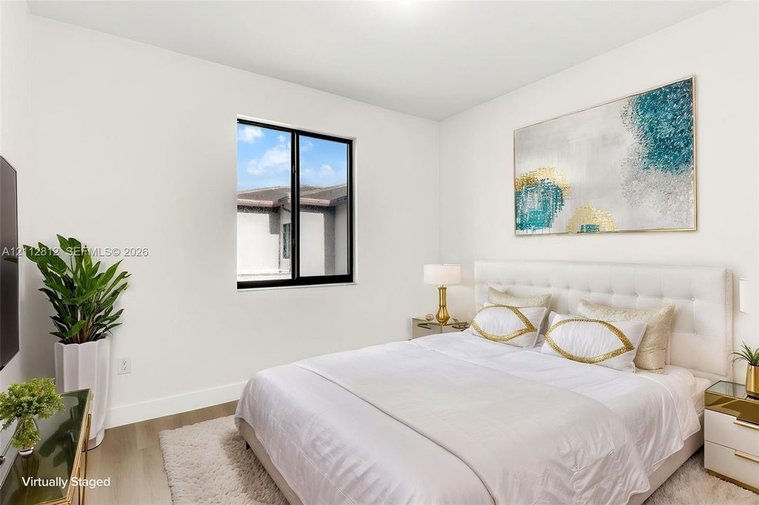 Neutral interior room featuring wood-finish flooring and a single-pane window with a black frame