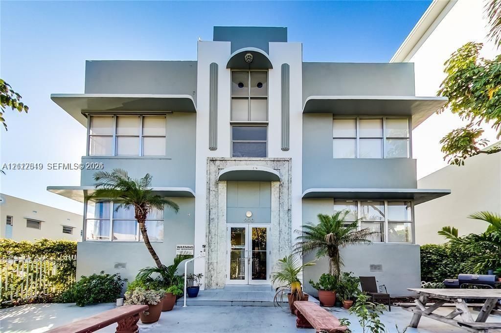 Art Deco exterior featuring symmetrical geometric lines, stepped roofline, horizontal cantilevered roof accents, and a central stone-clad entryway