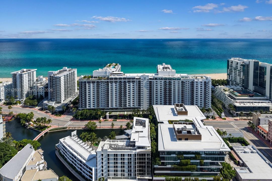 Aerial perspective of coastal high-rise property featuring balconies, rooftop pools, and water frontage