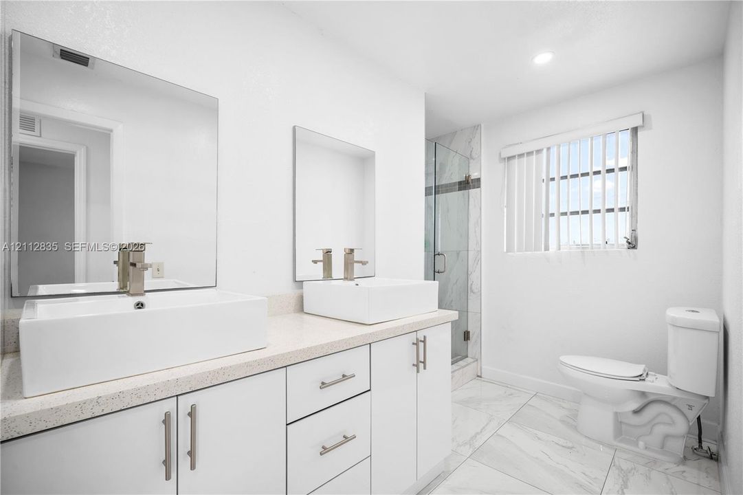 Spacious main bathroom with DOUBLE-SINK VANITY and generous storage.