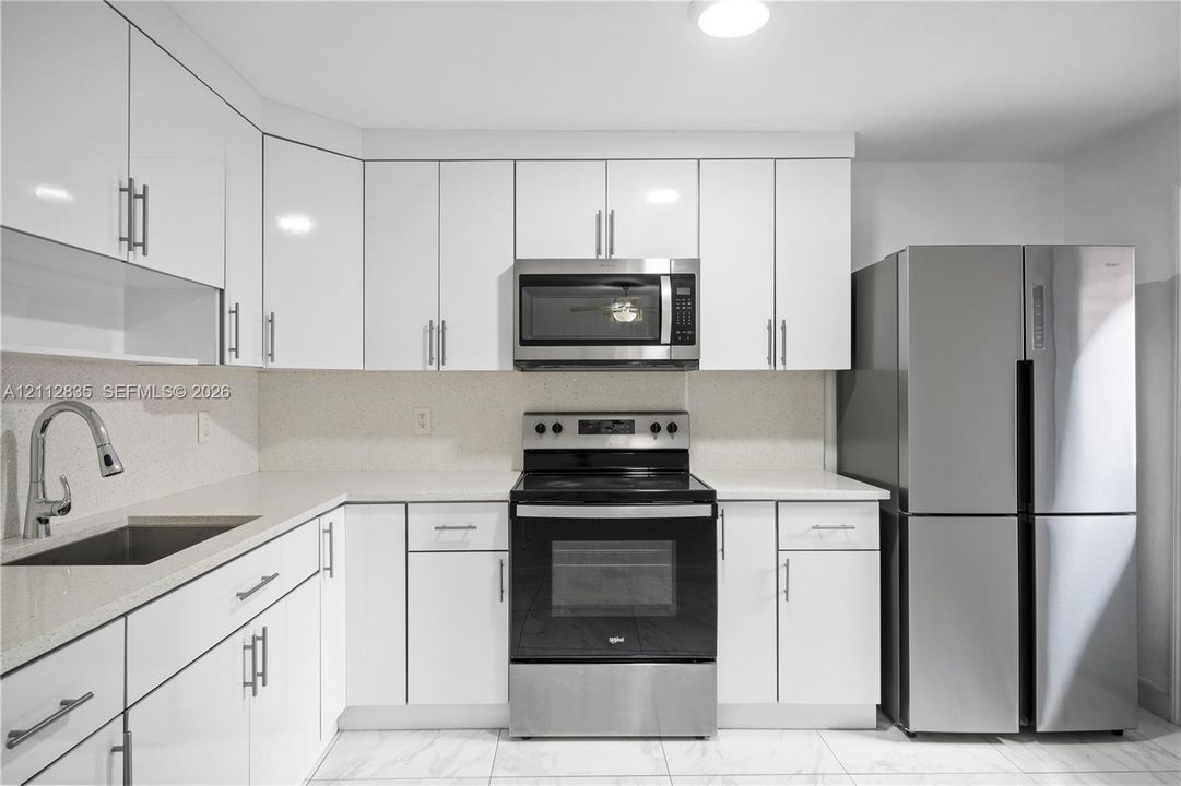 Welcome home! Bright, inviting kitchen with white cabinetry, stainless steel appliances, and plenty of storage.