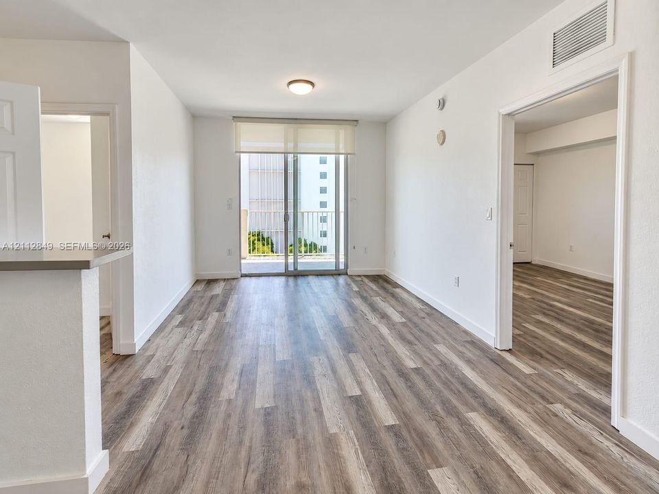 Open-concept room featuring wood-finish flooring, a glass sliding door, and a built-in counter surface