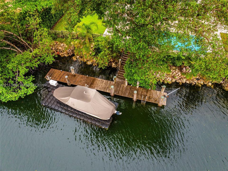 Private wooden dock featuring a fixed pier, integrated ladder, and a modular floating boat lift