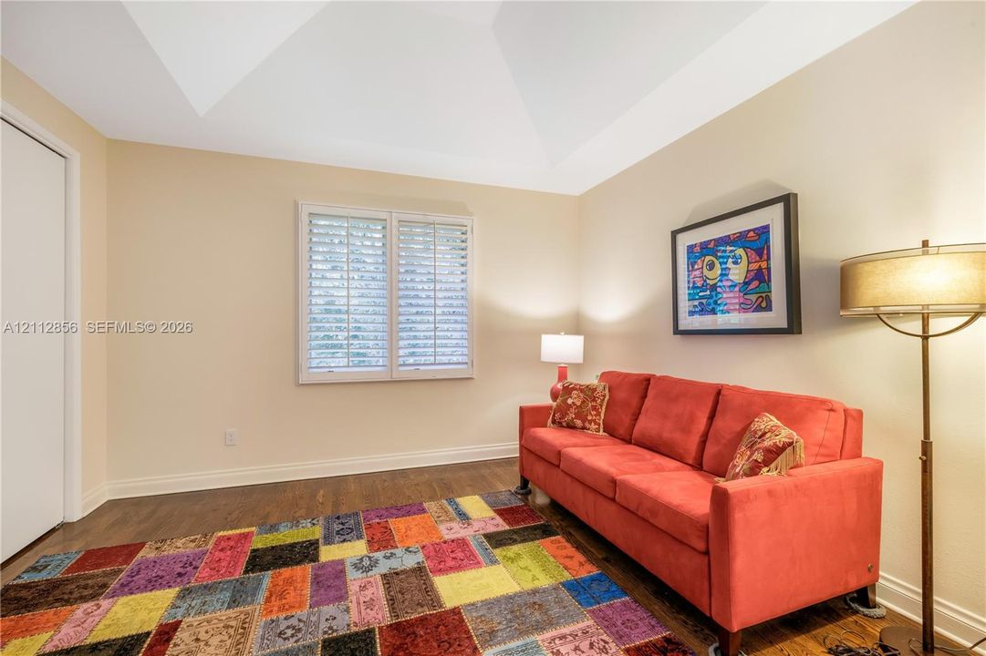 Vaulted ceiling, wood-finish flooring, and window shutters