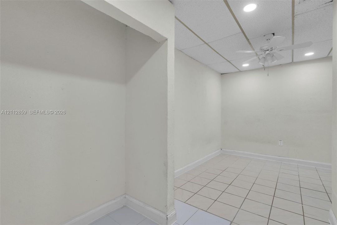 Interior space featuring light-toned tile flooring, recessed lighting, and a ceiling fan