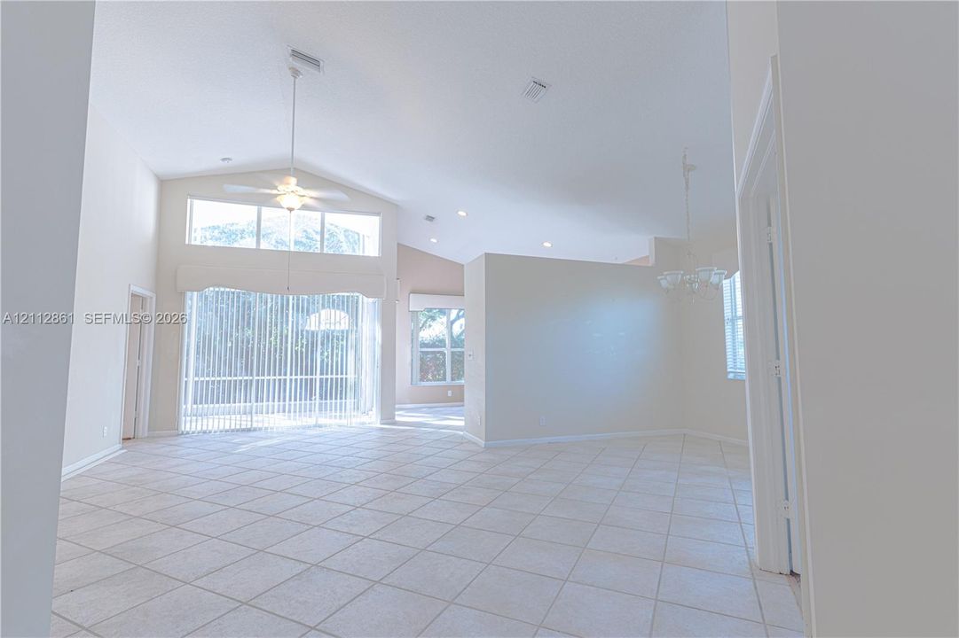 High vaulted ceilings featuring recessed lighting, tile flooring, large-scale window transoms, and a central ceiling fan