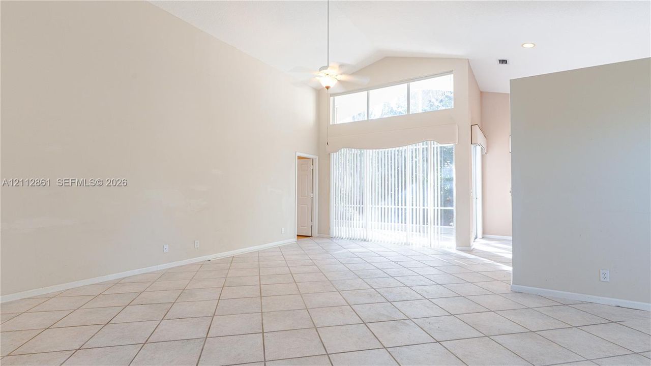 High vaulted ceilings, ceramic tile flooring, transom windows, and a ceiling fan