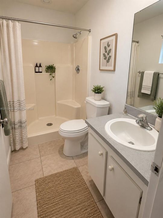 Full bathroom featuring a single-basin vanity with a stone-finish countertop, ceramic tile flooring, and a molded shower enclosure with built-in seating