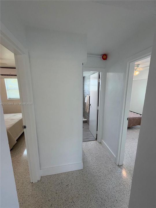 Interior hallway featuring light-toned terrazzo flooring and solid-core interior doors
