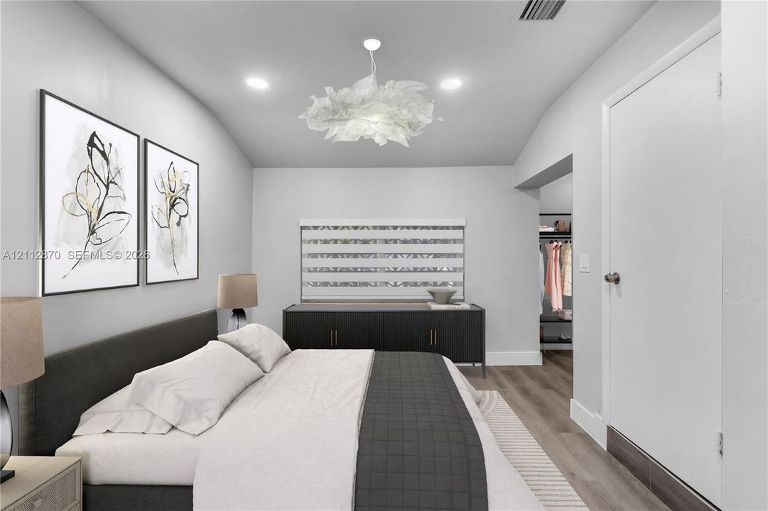 Bedroom featuring vaulted ceilings, wood-finish flooring, recessed lighting, and a decorative ceiling fixture