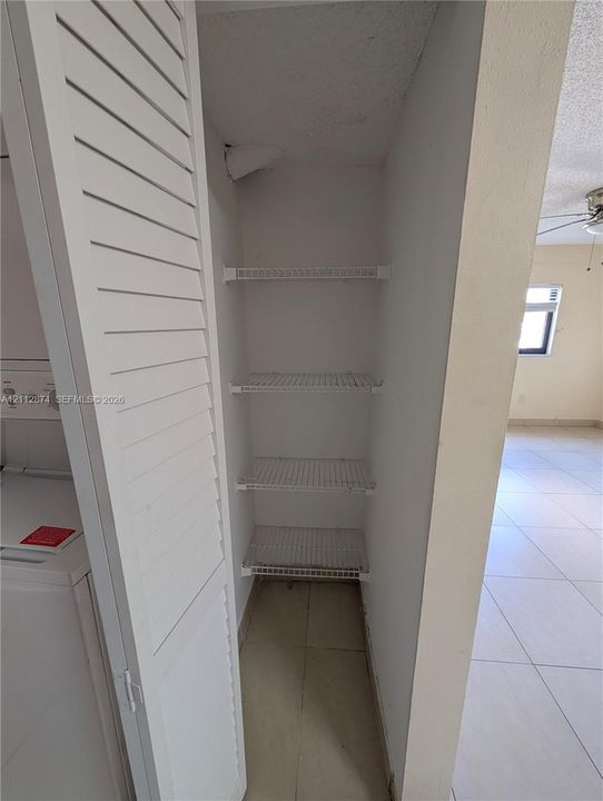 Storage closet featuring louvered bi-fold doors and multiple wire-frame shelves