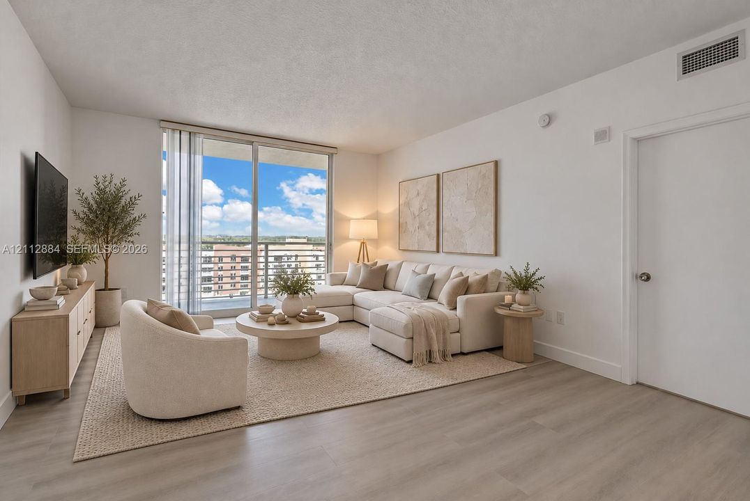 Living area featuring wood-finish flooring, floor-to-ceiling glass sliding doors, and a private balcony