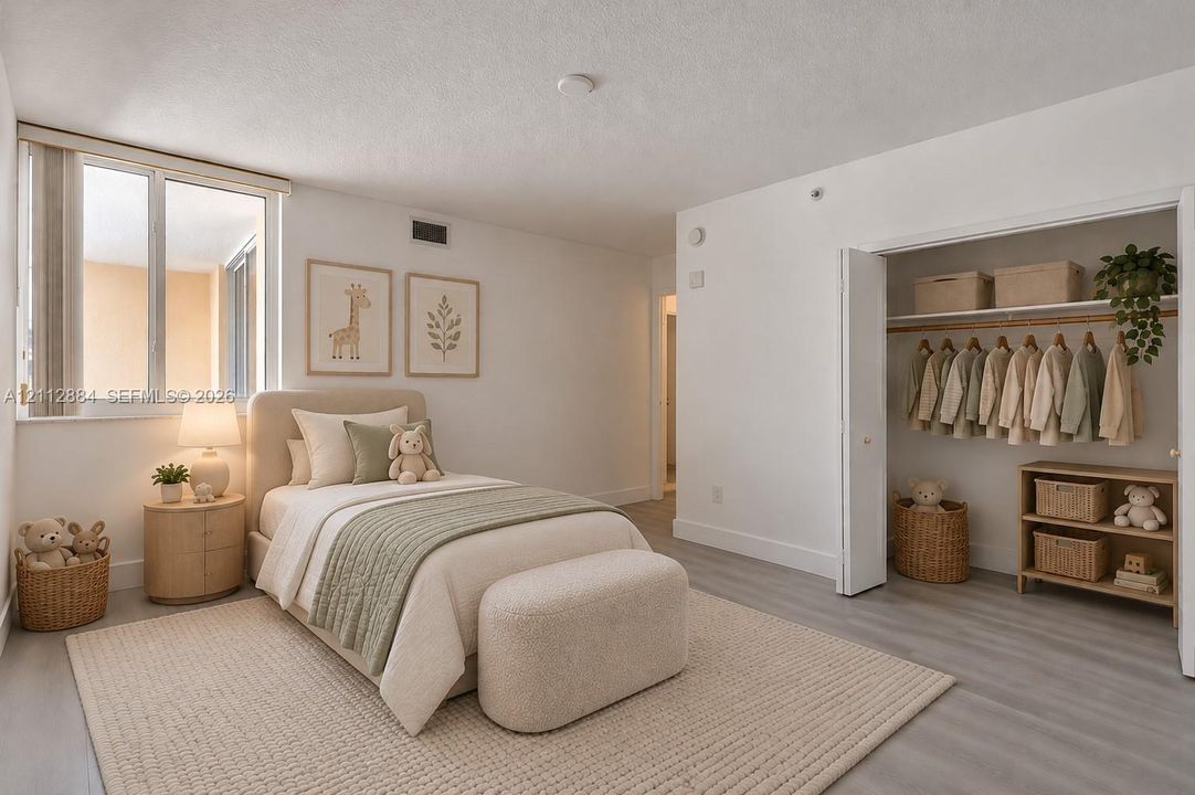 Bright room featuring wood-finish flooring, a large window, and a built-in closet with double-panel doors