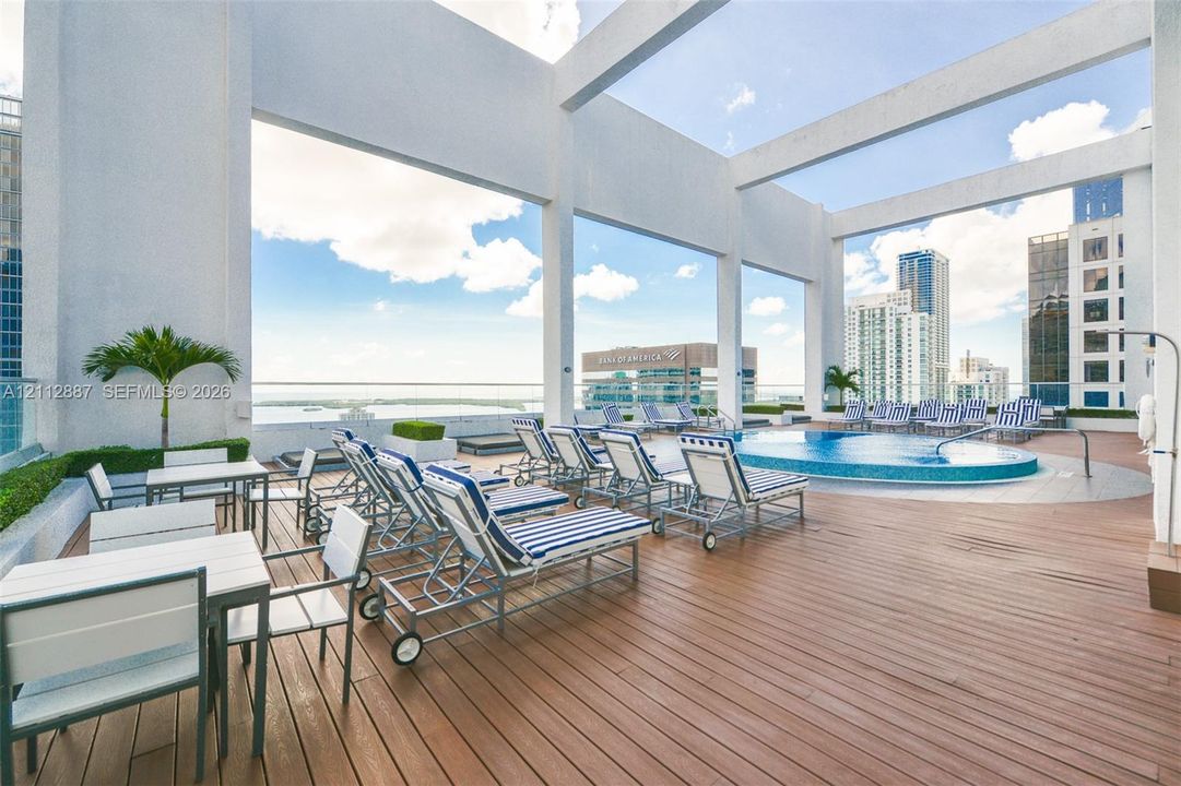Rooftop terrace featuring wood-finish decking, an elevated swimming pool with tiled surround, and structural pergola framing