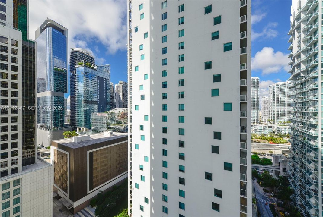High-rise exterior featuring a white facade with recessed square windows and vertical balcony tiers