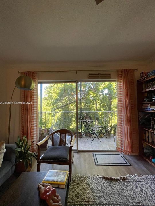 Sliding glass door leading to a balcony with metal railings and light-toned flooring