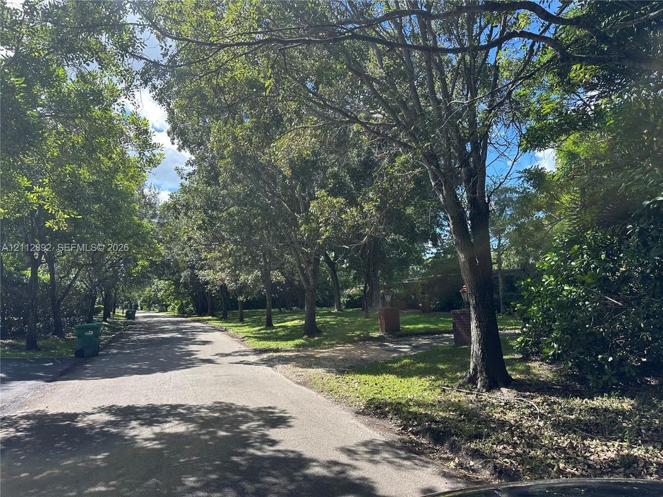 Spacious lot featuring mature trees, expansive green space, and a brick-pillared entrance