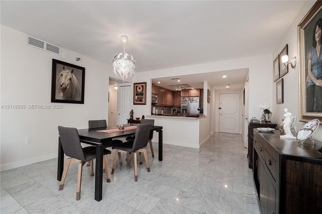 Stone tile flooring, decorative multi-faceted globe pendant lighting, recessed ceiling lighting, and pass-through opening with countertop