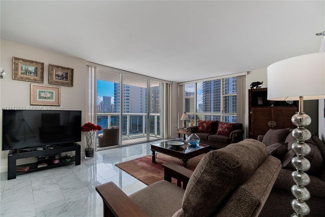 Polished stone flooring, expansive glass sliding doors, and floor-to-ceiling windows
