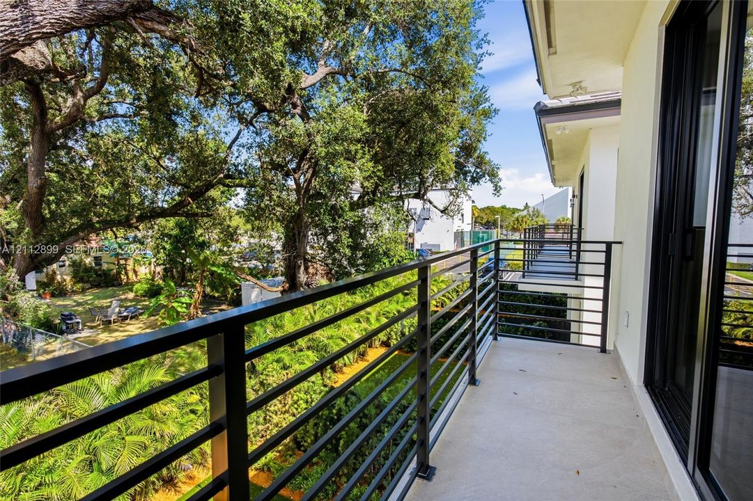 Covered balcony featuring concrete flooring and a black horizontal metal railing