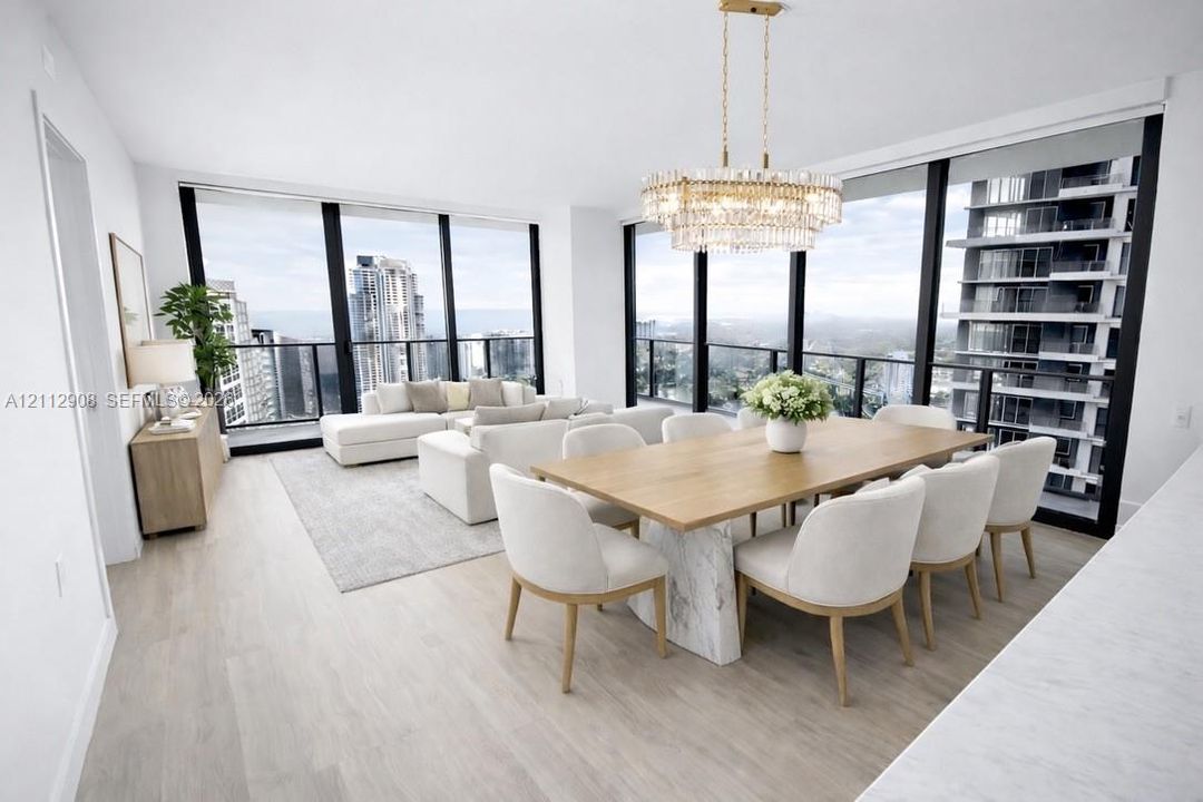 Open-concept floor plan featuring floor-to-ceiling windows, wood-finish flooring, and a multi-tiered crystal chandelier